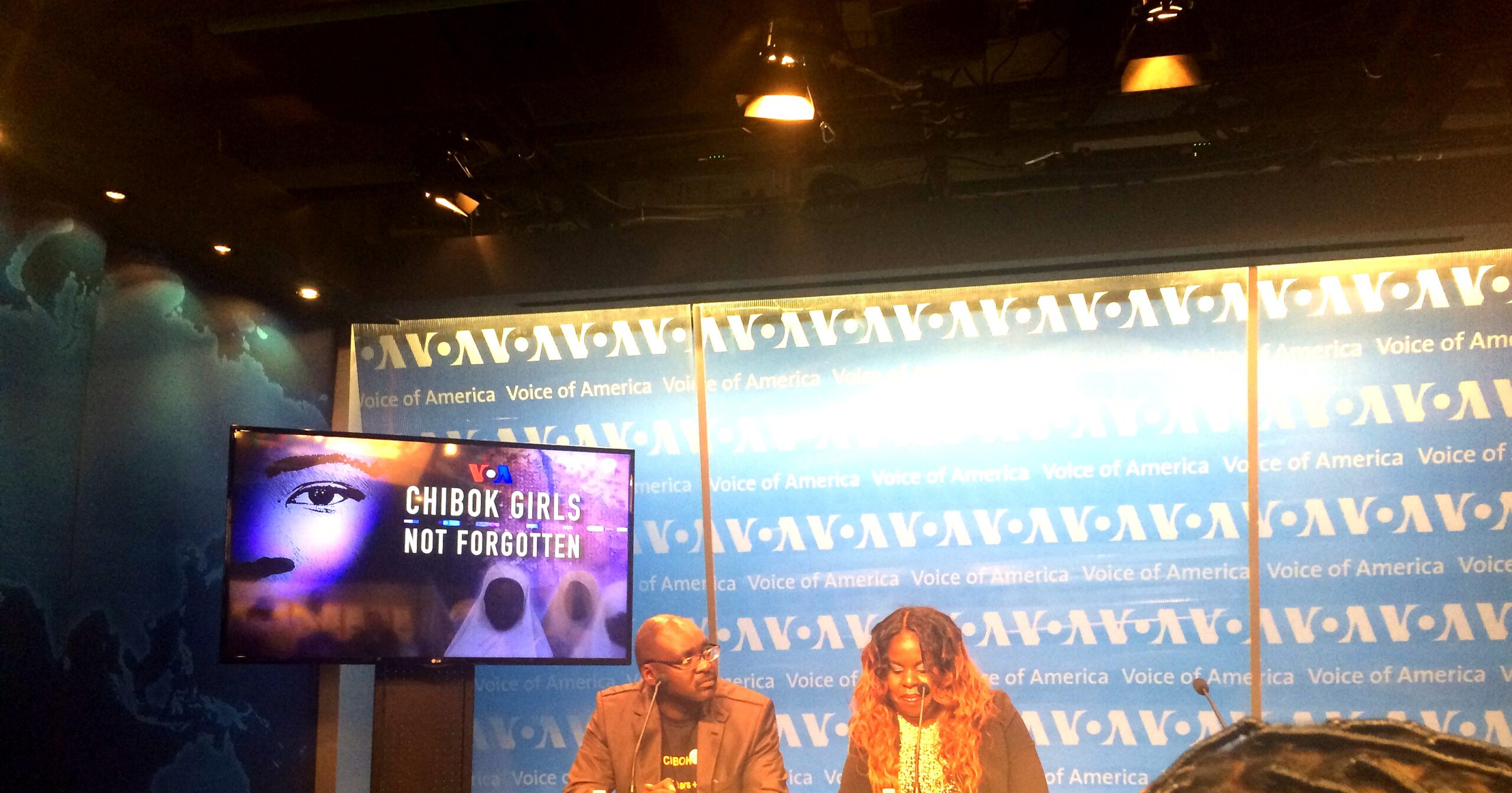 Sandra Ekpenyong at the VOA broadcast table with nameplate